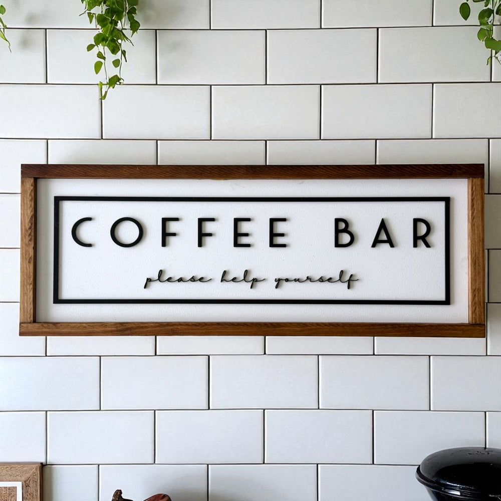Wooden-framed 'COFFEE BAR please help yourself' sign on a tiled wall.