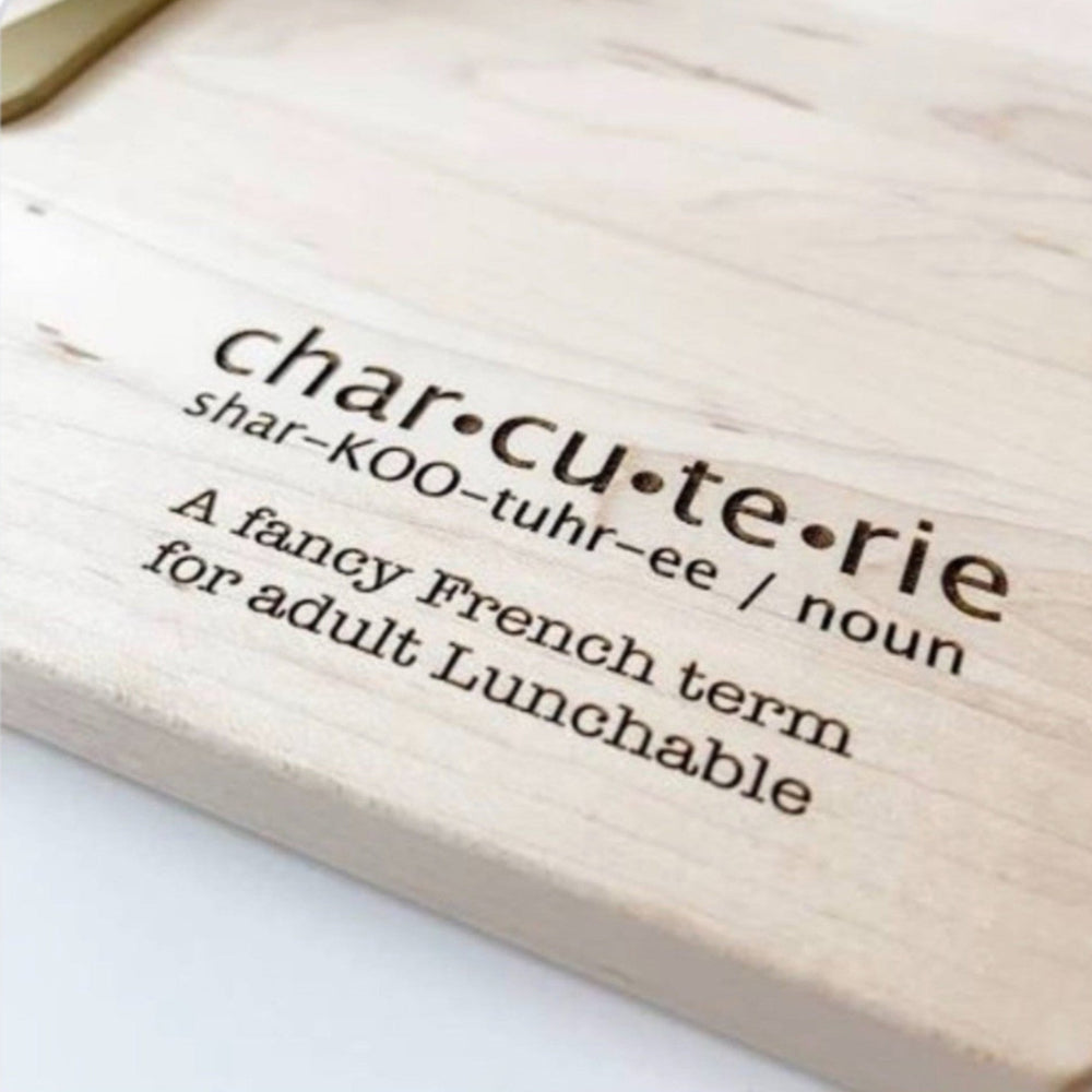 Wooden cutting board with 'charcuterie' definition text on a white background