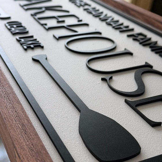 Decorative sign with paddle design and text on a wooden background