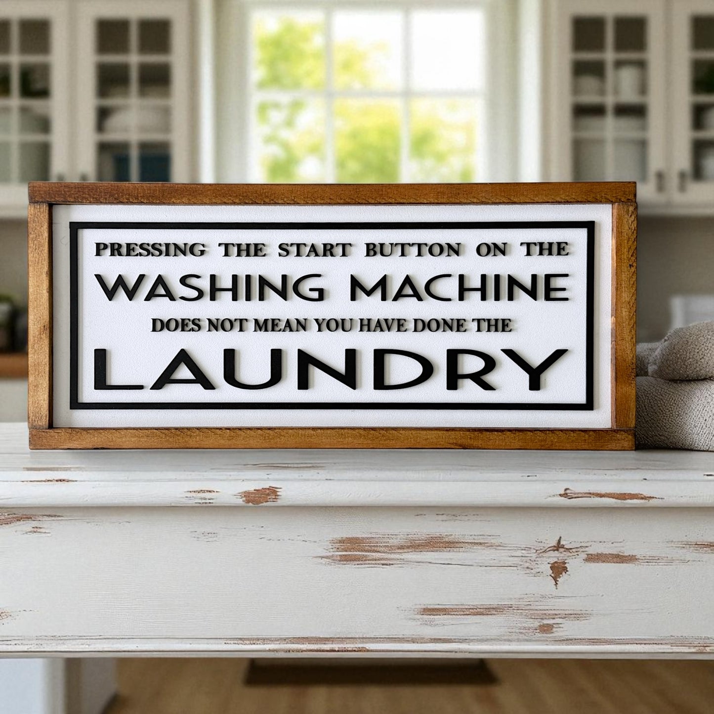 Wooden sign with humorous laundry quote on a white surface