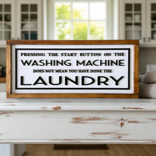  Wooden sign with humorous laundry quote on a white surface