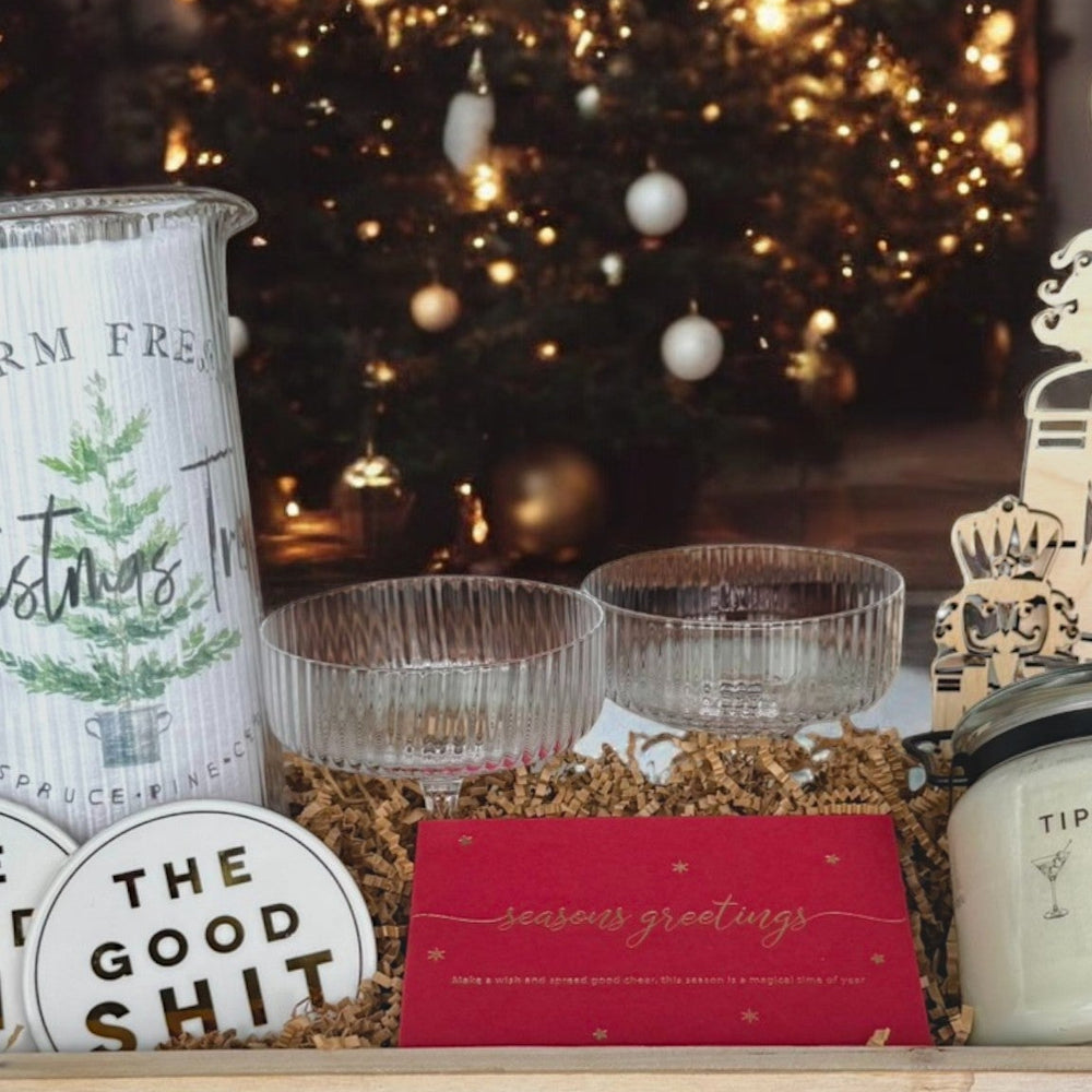 Decorative items including a mug, candles, and signs in front of a Christmas tree.