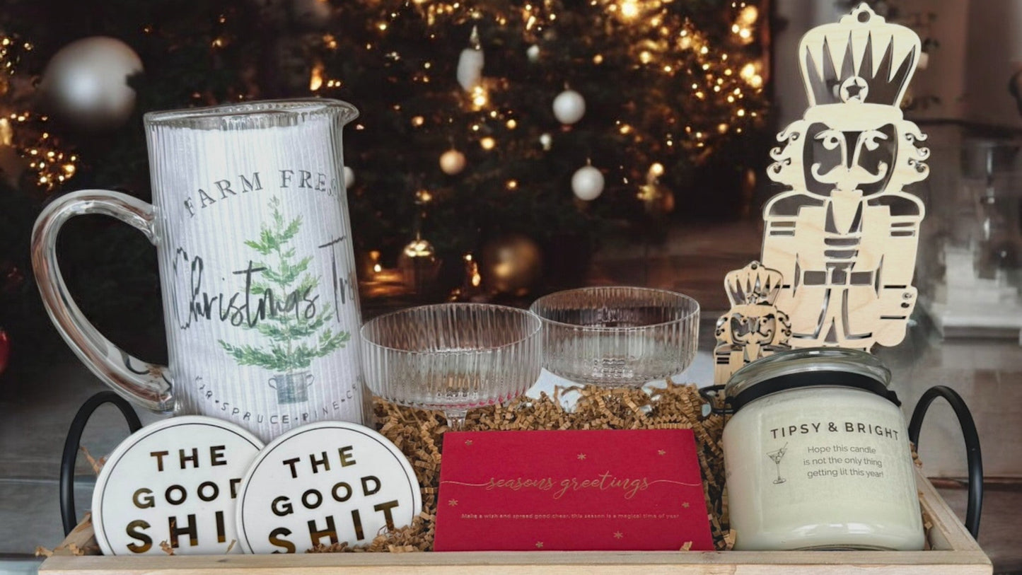 Decorative items including a mug, candles, and signs in front of a Christmas tree.