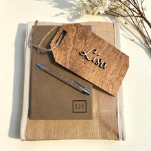 Notebook with pen and wooden tag on a light background