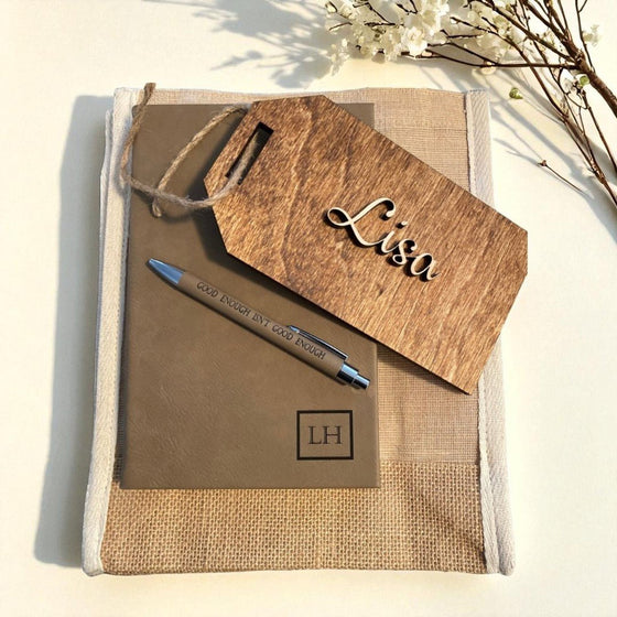 Notebook with pen and wooden tag on a light background