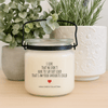 Mother’s Day soy candle with label that reads “I Love That We Don’t Have to Say Out Loud That I Am Your Favourite Child” on a wood table with small planters and greenery