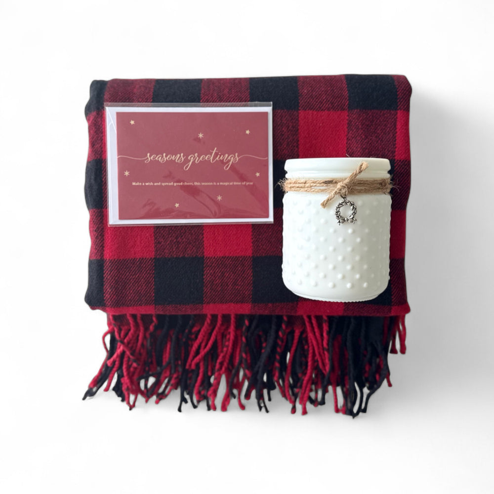 
                  
                    Red and black plaid blanket with a white textured jar and 'seasons greetings' card on a white background
                  
                