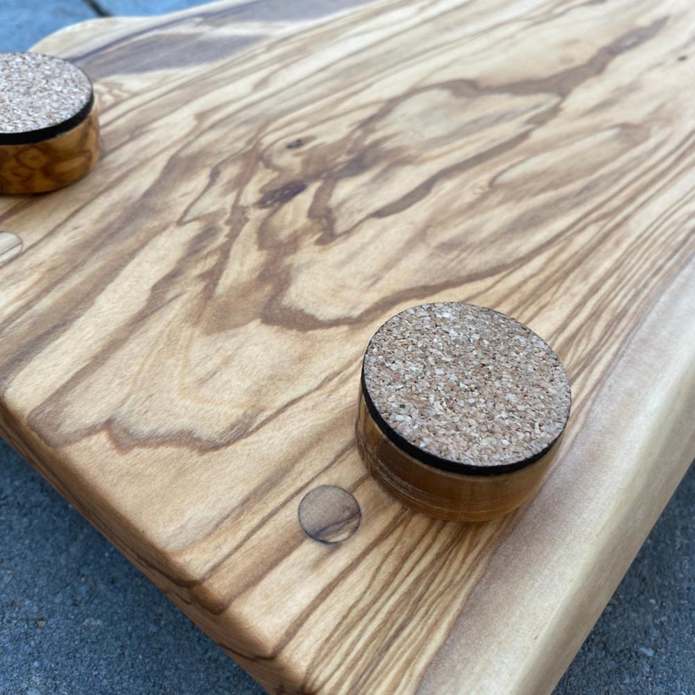 
                  
                    Backside of Olivewood Live Edge Charcuterie Board  showing corked round feet
                  
                