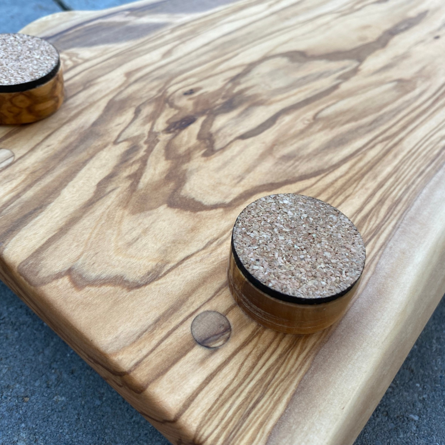 Backside of Olivewood Live Edge Charcuterie Board  showing corked round feet