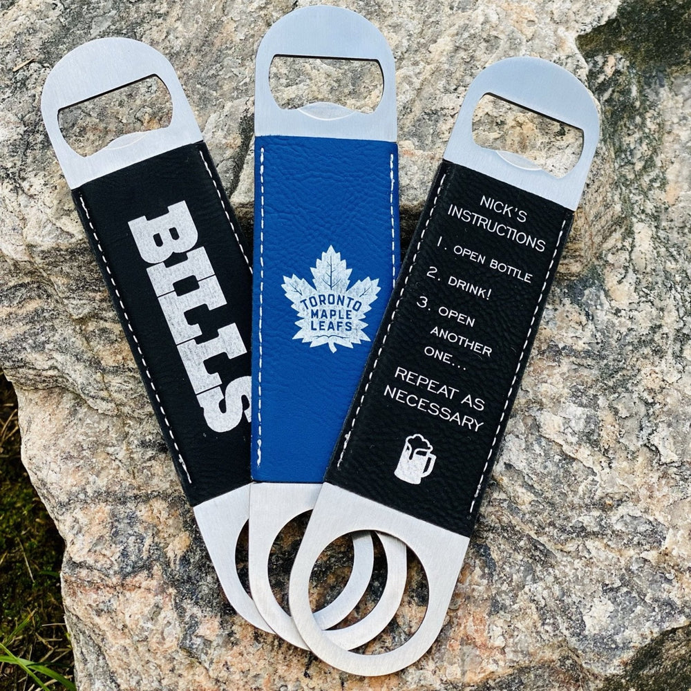 
                  
                    3 Leatherette Bottle Openers with sports team engraved on the front. 1 Blue, 2 Black - The Red Door Engraving Company Inc.
                  
                
